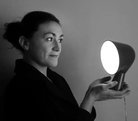 A portrait of Ionna Vautrin holding up her Binic lamp